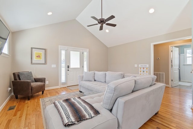 living room with light hardwood / wood-style floors, high vaulted ceiling, plenty of natural light, and ceiling fan