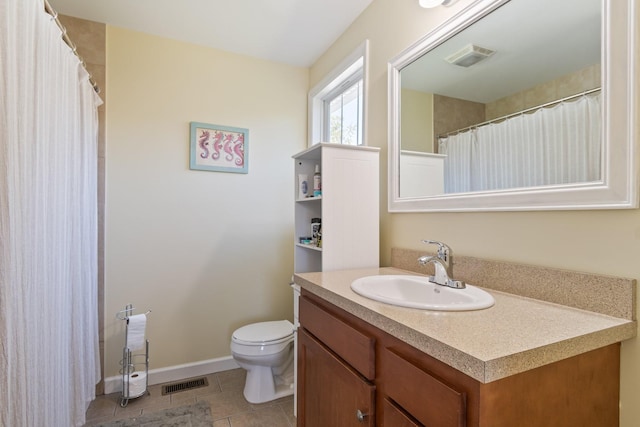 bathroom with tile patterned flooring, vanity, and toilet