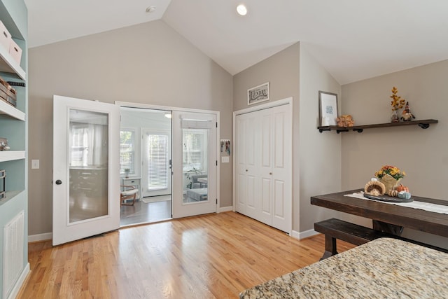 entryway with french doors, high vaulted ceiling, and light hardwood / wood-style flooring