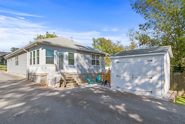 rear view of property with a patio area and a shed