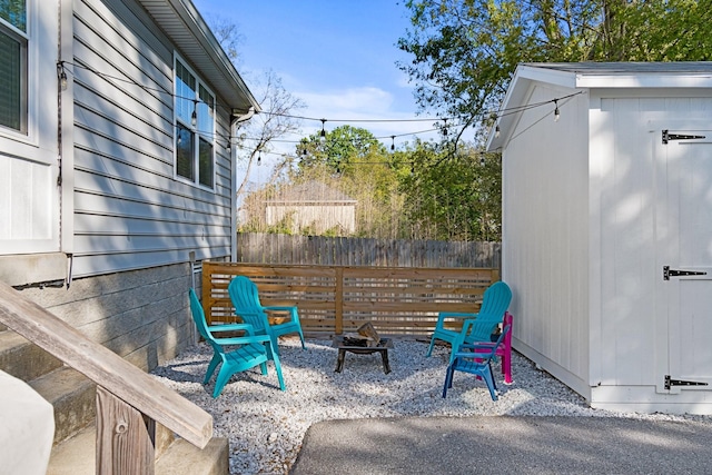 view of patio / terrace with a storage shed and an outdoor fire pit