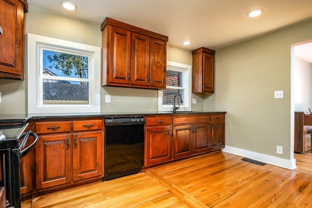 kitchen featuring sink, light hardwood / wood-style floors, and black appliances