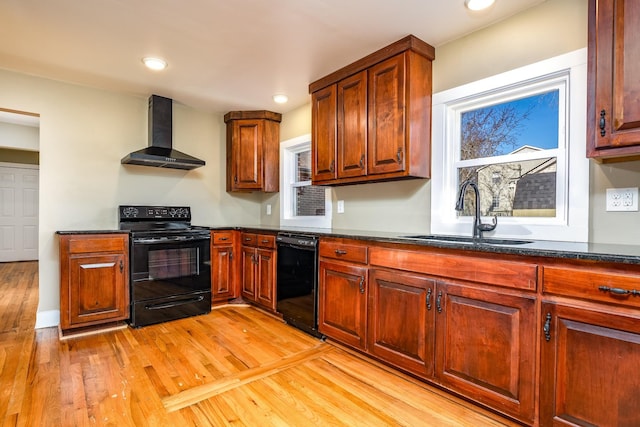 kitchen featuring black appliances, sink, light hardwood / wood-style floors, and wall chimney exhaust hood