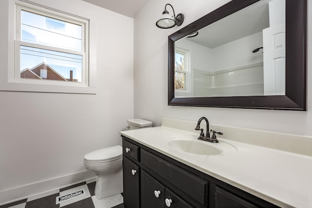 bathroom with vanity, toilet, and a shower