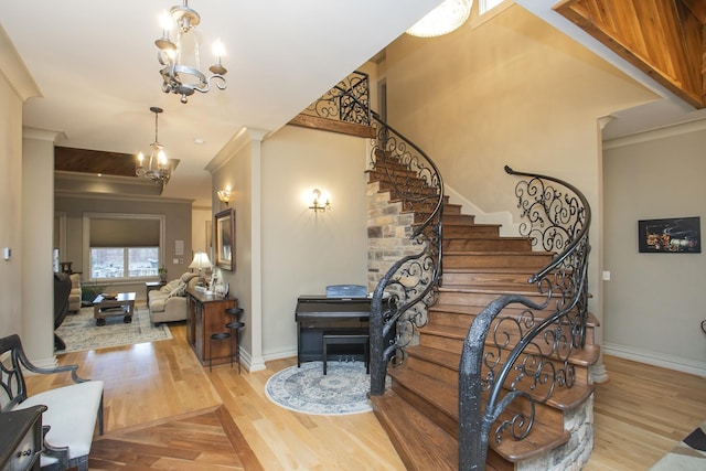 stairs featuring ornamental molding, a chandelier, and hardwood / wood-style floors