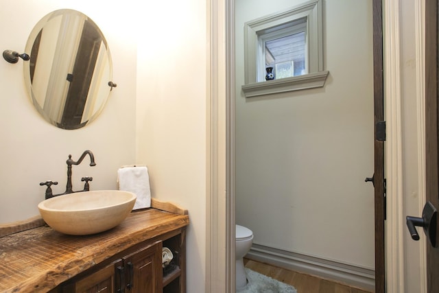 bathroom with vanity, wood-type flooring, and toilet