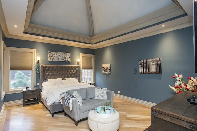 bedroom with a tray ceiling, ornamental molding, and light hardwood / wood-style floors