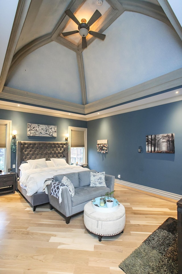 bedroom with ceiling fan, high vaulted ceiling, and light hardwood / wood-style flooring