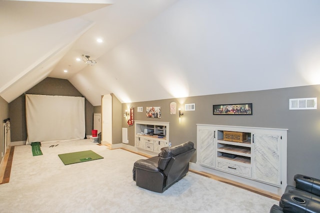 home theater featuring vaulted ceiling, golf simulator, and built in shelves