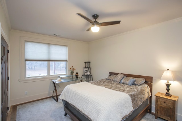 carpeted bedroom with ornamental molding and ceiling fan