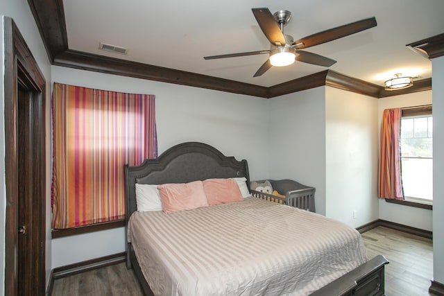 bedroom featuring hardwood / wood-style flooring, ceiling fan, and ornamental molding