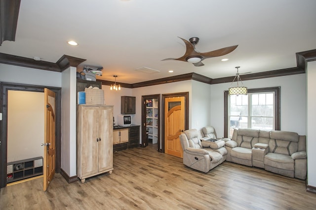 living room with hardwood / wood-style floors, ornamental molding, and ceiling fan