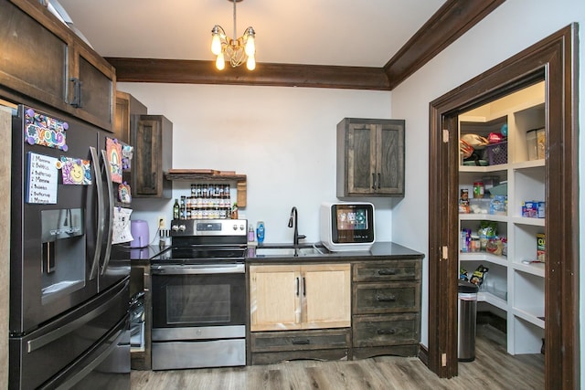 kitchen featuring sink, crown molding, an inviting chandelier, stainless steel appliances, and light wood-type flooring