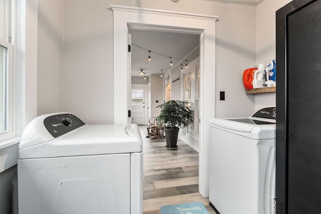 clothes washing area featuring washing machine and dryer and light wood-type flooring