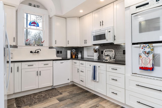 kitchen with tasteful backsplash, white cabinetry, dark hardwood / wood-style flooring, and white appliances