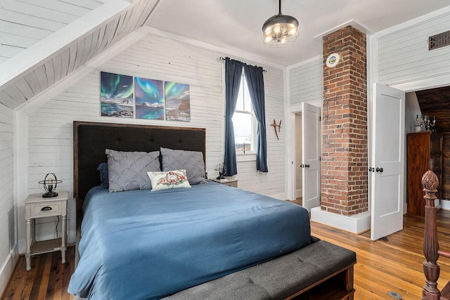 bedroom featuring wood walls and wood-type flooring