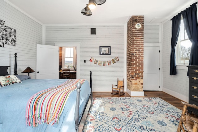 bedroom with hardwood / wood-style flooring, crown molding, and wooden walls