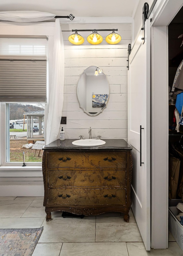 bathroom with tile patterned floors, vanity, and wooden walls