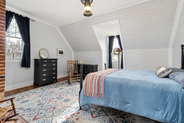 bedroom with wood-type flooring, lofted ceiling, and wooden walls