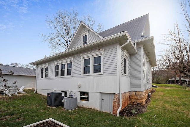 view of property exterior with a yard and central AC