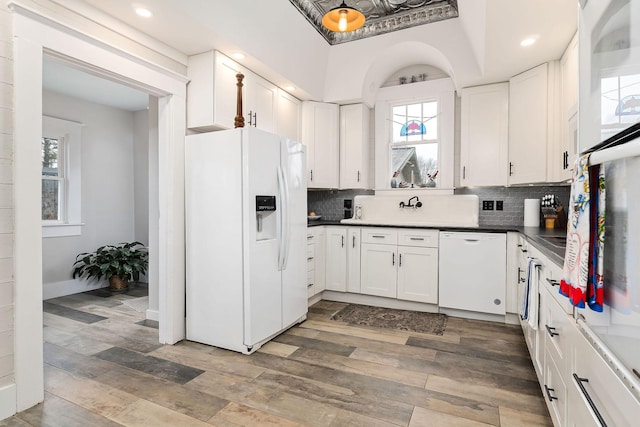 kitchen featuring plenty of natural light, white cabinets, and white appliances