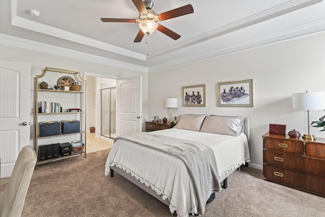 carpeted bedroom with a tray ceiling, ceiling fan, and crown molding