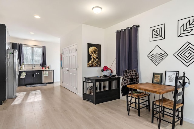 dining room featuring light wood-type flooring and sink