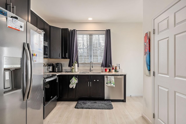 kitchen with sink, appliances with stainless steel finishes, and light hardwood / wood-style flooring