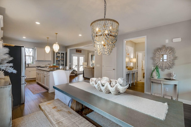 dining space featuring french doors, a chandelier, and dark hardwood / wood-style floors