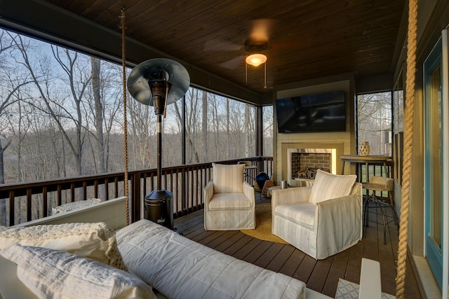 sunroom featuring ceiling fan and wooden ceiling