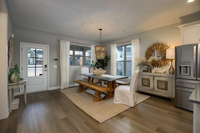 dining area with dark hardwood / wood-style flooring and a chandelier