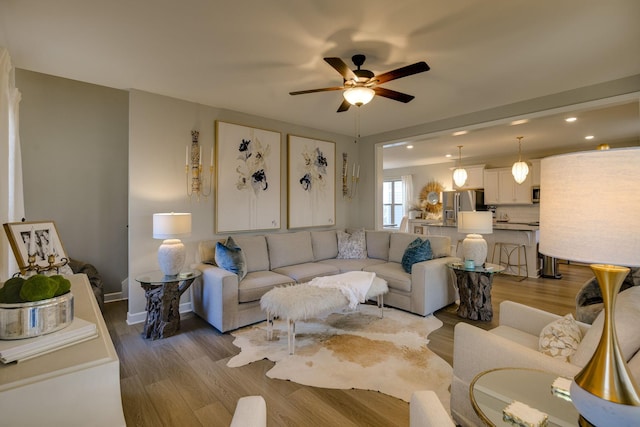 living room with light hardwood / wood-style floors and ceiling fan