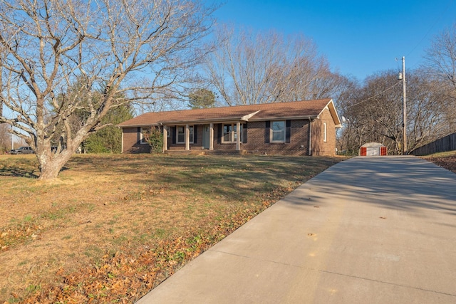 single story home with a porch, a garage, an outdoor structure, and a front yard