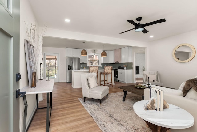 living room with light wood-type flooring and ceiling fan