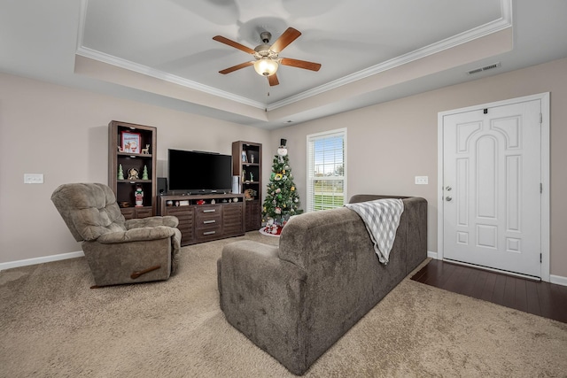 living room featuring hardwood / wood-style floors, ceiling fan, and a raised ceiling