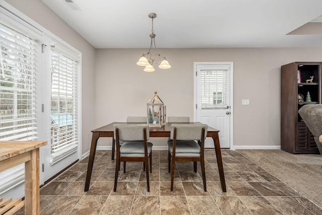 carpeted dining space with an inviting chandelier