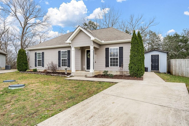 view of front of house with a front lawn, a storage unit, and cooling unit