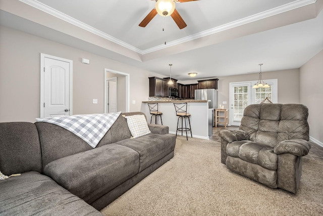 living room with ceiling fan, carpet floors, and ornamental molding