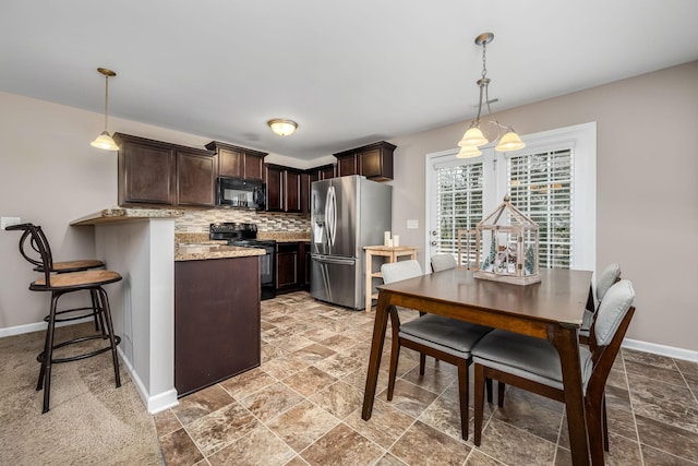 kitchen with backsplash, black appliances, decorative light fixtures, dark brown cabinets, and kitchen peninsula