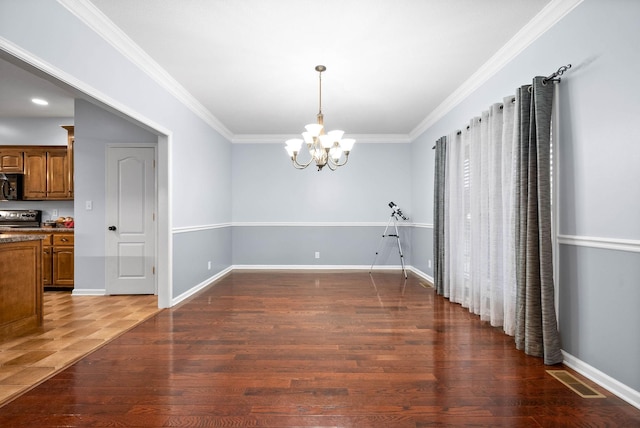 dining area featuring dark wood-type flooring, crown molding, and a notable chandelier