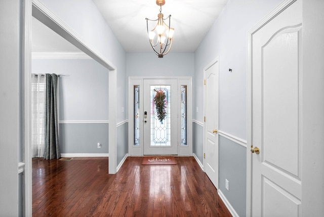 entryway with dark wood-type flooring and a chandelier