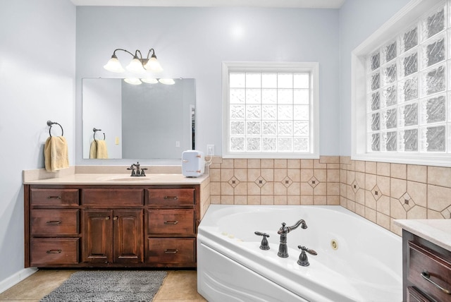 bathroom with a washtub, tile patterned floors, and vanity