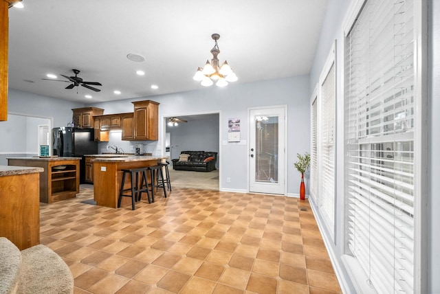 kitchen featuring a breakfast bar area, a chandelier, a kitchen island, pendant lighting, and sink