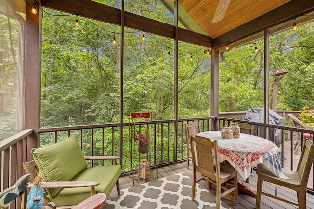 sunroom with vaulted ceiling, ceiling fan, and wood ceiling