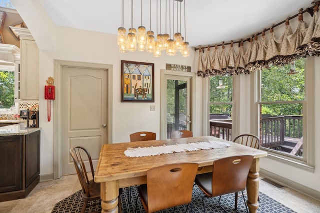 dining space with a wealth of natural light and a notable chandelier