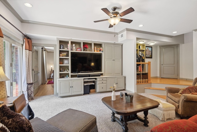 carpeted living room featuring ceiling fan and built in desk