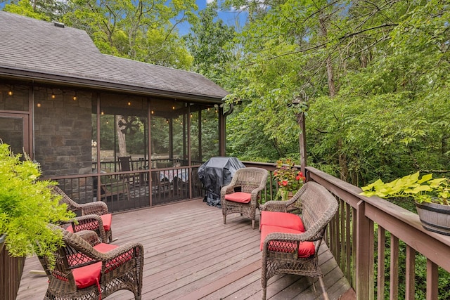 deck with a grill and a sunroom