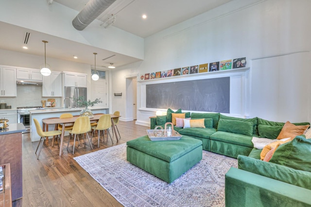 living room with dark hardwood / wood-style floors and a high ceiling