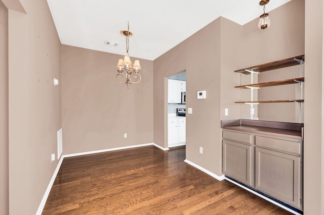 unfurnished dining area with a chandelier, dark hardwood / wood-style floors, and lofted ceiling