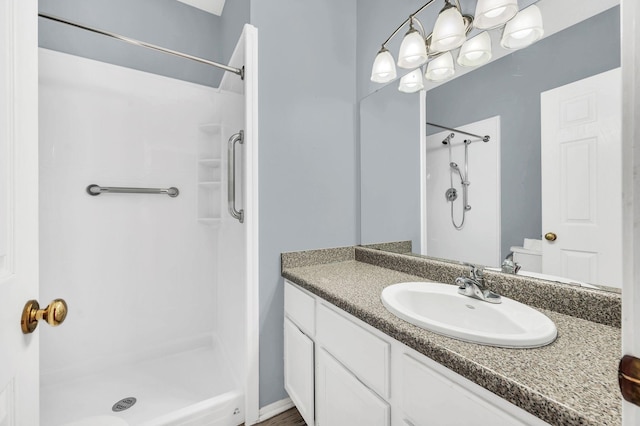 bathroom featuring a shower and vanity